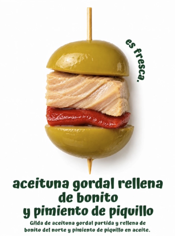 Cartel «es fresca»: gilda de aceituna gordal partida y rellena de bonito del norte y pimiento de piquillo en aceite.